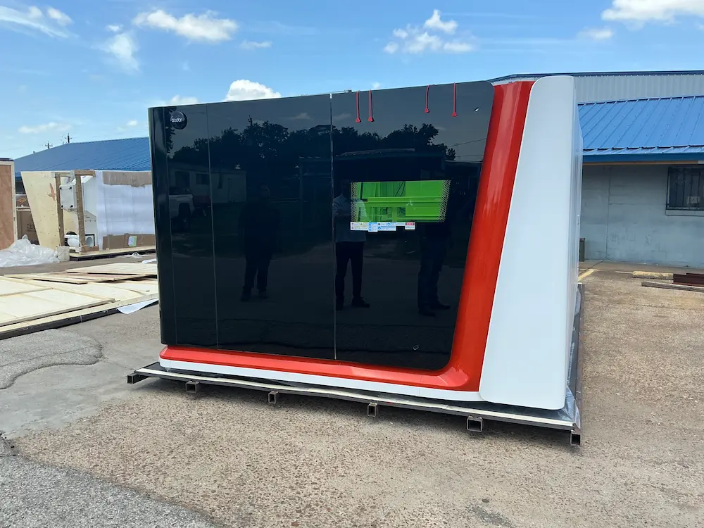 Front view of an enclosed Bodor industrial fiber laser cutting machine sitting on a transport frame.